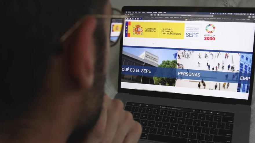 Un home mirant la pàgina web del SEPE.