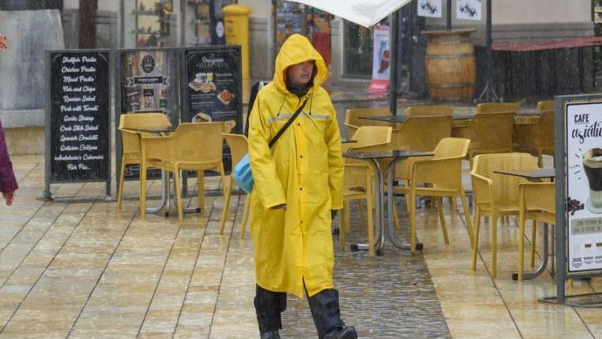 Mujer andando bajo la lluvia en Murcia