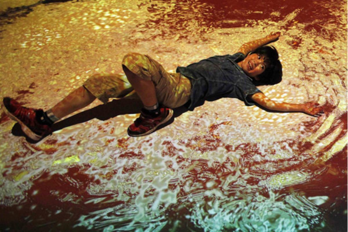 Un nen prova una fregidora virtual en una atracció interactiva del museu Cup Noodles a Tòquio (Japó).