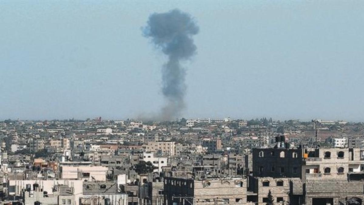 Una columna de humo se eleva sobre la ciudad de Rafá, en el sur de la franja de Gaza, tras un bombardeo israelí, ayer, tras la ruptura de la tregua.