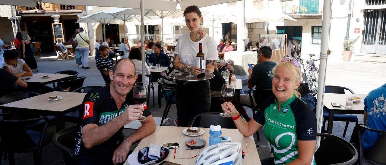 Deportistas extranjeros disfrutan en la terraza del restaurante As Greas