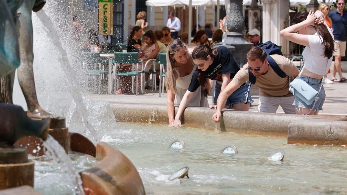 Varias personas se refrescan en una fuente de València