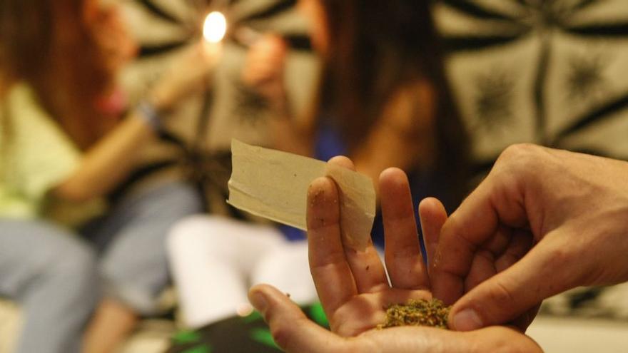 Un joven se lía un porro de marihuana, en compañía de otras dos chicas, en una imagen de archivo.