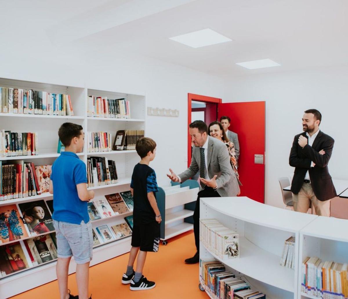 El alcalde de La Victoria saluda a dos jóvenes usuarios de la biblioteca. | | EL DÍA