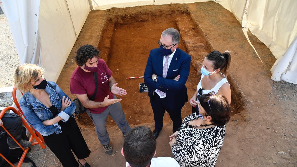 El presidente José Martí y la diputada Tania Baños, junto a demás autoridades, frente a una fosa.