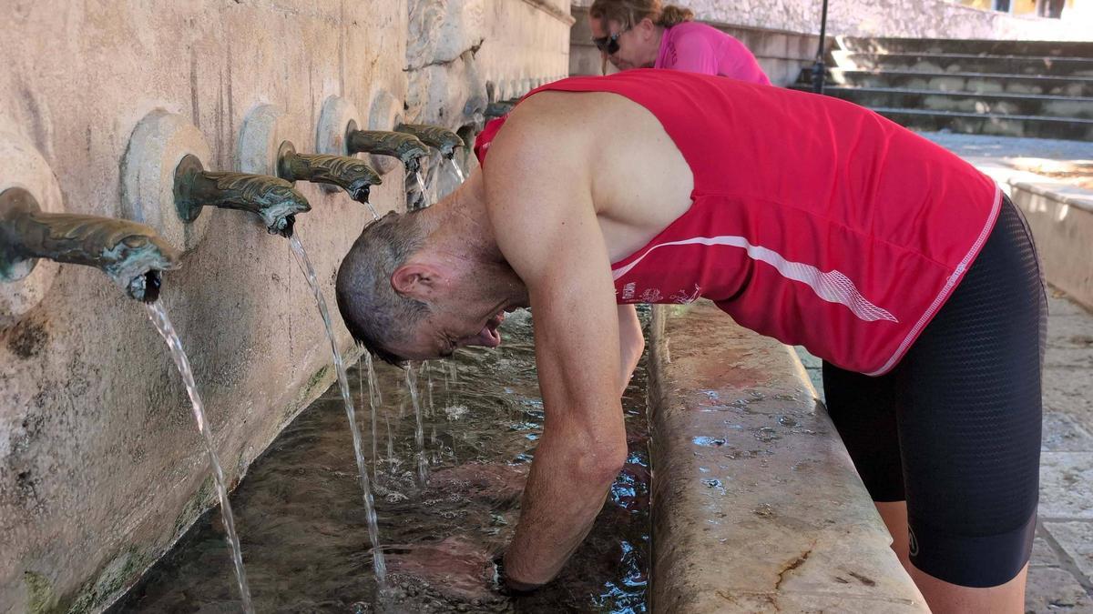 Imagen de archivo de un hombre refrescándose en la "Font dels 25 dolls" de Xàtiva.