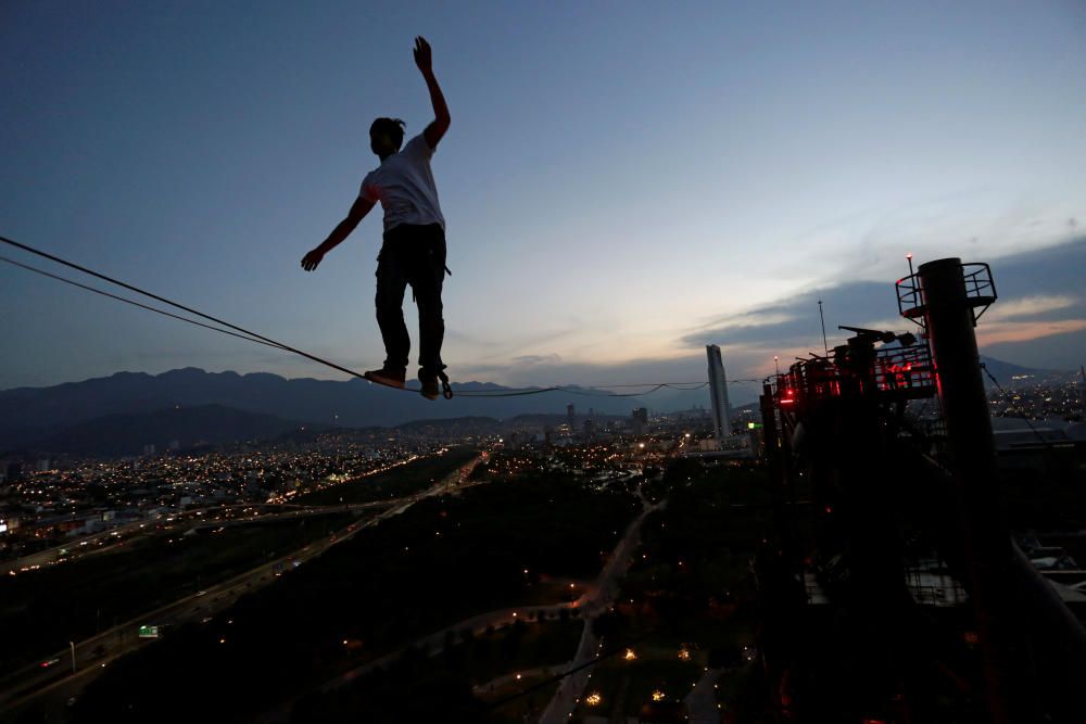 A slackliner crosses a high wire between two ...