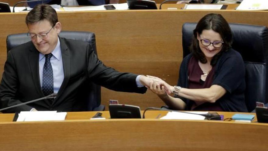 El jefe del Consell, Ximo Puig, recibe un gesto afectuoso de la vicepresidenta Oltra, ayer.