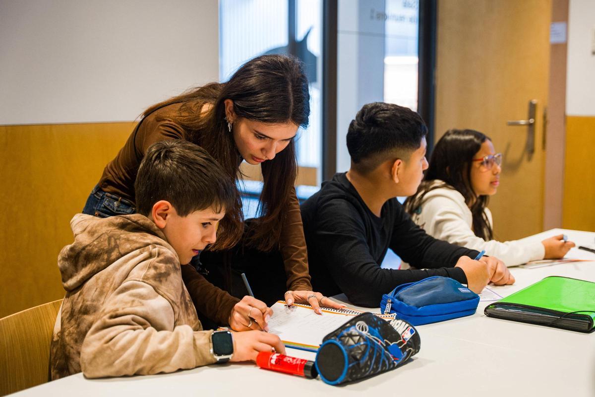 Judith, educadora de los talleres de catalán de El Prat, ayuda a Leonardo con unos ejercicios.