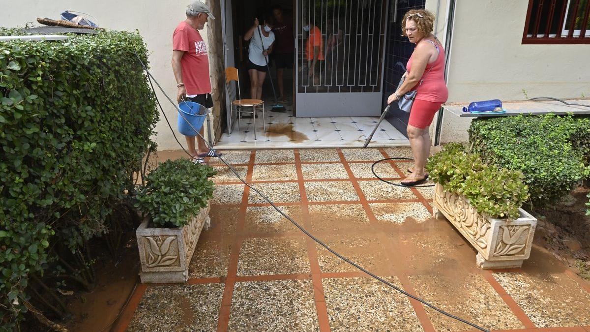 Vecinos del bloque de apartamentos La Gaviota, en la calle Sigalero, seguían limpiando este lunes el agua acumulada en la entrada al portal.