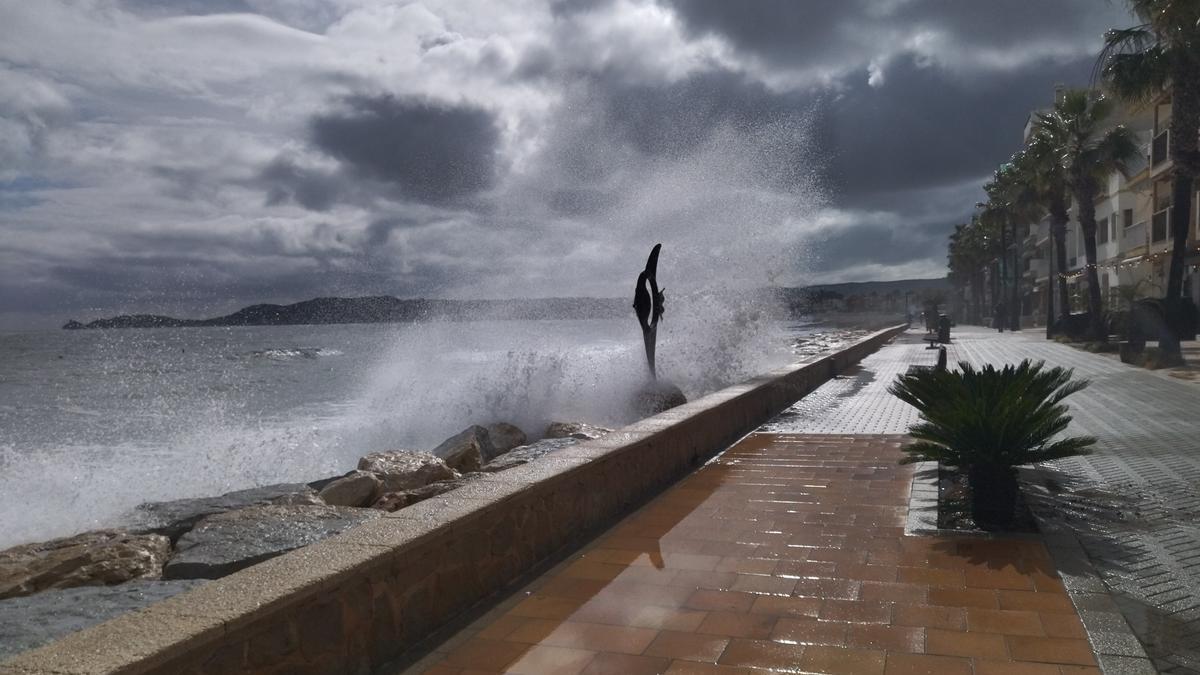 Una ola rompe y cae en el paseo de la Marina Española