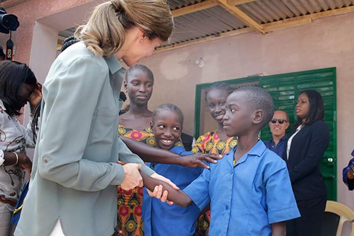 Letizia Ortiz saluda a un niño en una granja familiar en Naatangue, Senegal