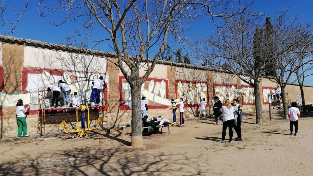 Jóvenes pintan el mural por la paz en un muro trasero del convento de las Carmelitas de Toro. | M. J. C.