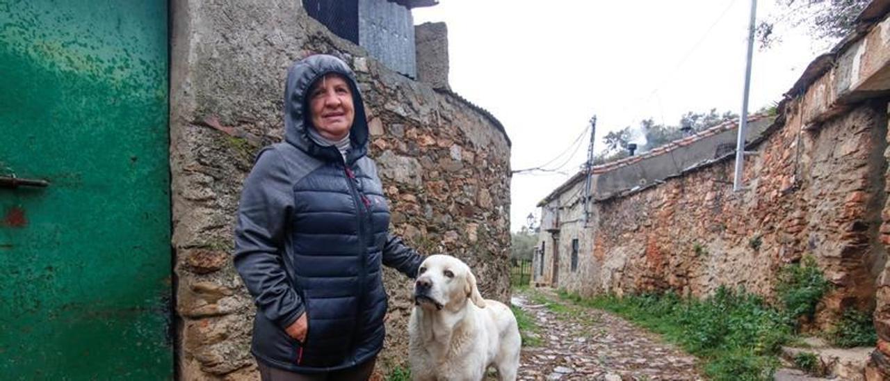 Emilia Fernández junto a su perro Leo, a las puertas de su corral