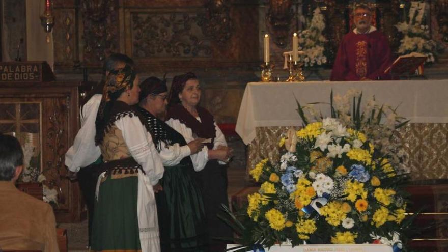 El grupo de baile vaqueiro &quot;La Corte&quot; recita una copla ante el féretro de Carmen Martínez, ayer, en Luarca; en el recuadro, Carminina.