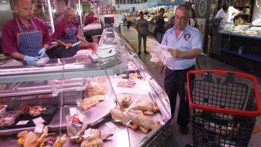 El vigilant del mercat, recollint productes a la polleria Imma · Aniol Resclosa