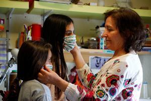 CO01. CÓRDOBA, 21/04/2020.- Una mujer prueba a dos niñas una mascarillas realizadas con un tamaño más pequeño para que puedan utilizarlas a partir del próximo lunes 27, tras el anuncio del Gobierno de que los menores de catorce años podrán acompañar a un adulto en las actividades que ya permite el estado de alarma, como ir al supermercado, a la farmacia o al banco. EFE/Salas