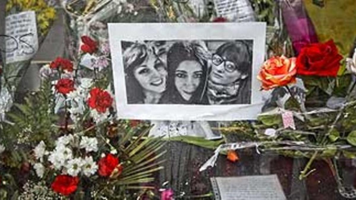 Flores y anotaciones junto a las fotos de tres de las cuatro víctimas mortales de la avalancha en el Madrid Arena, en la estación de La Alameda de Osuna.