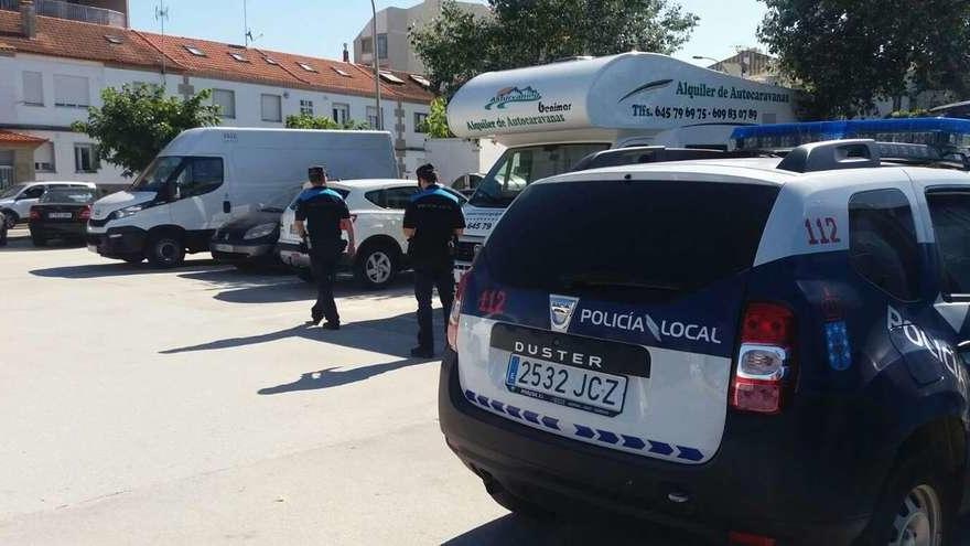 Agentes de la Policía Local de Cangas inspeccionando, ayer, las autocaravanas estacionadas junto a la playa de Rodeira. // G.Núñez