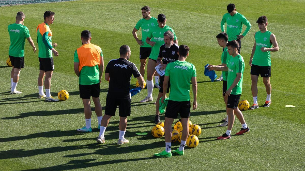 El preparador físico del Elche Martín Bressan, con un papel en la mano, en el centro de la imagen, durante un entrenamiento, en el campo Díez Iborra