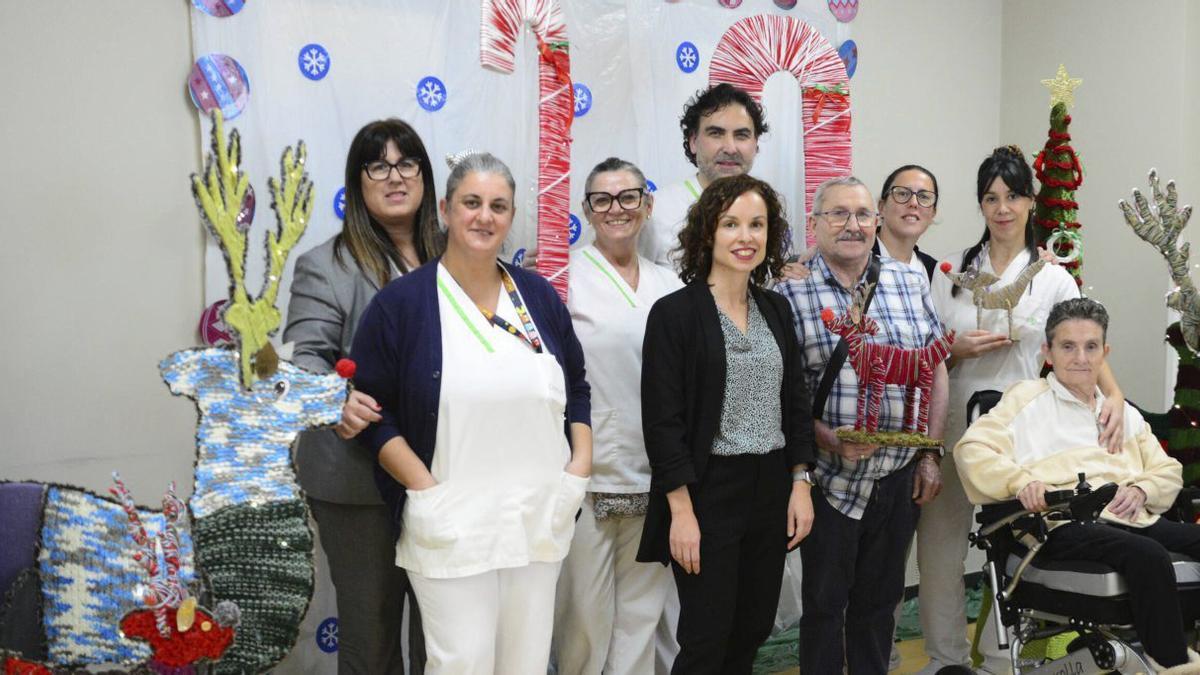 Residentes y trabajadores, en el ‘photocall’ diseñado en las clases de manualidades. |  DomusVi