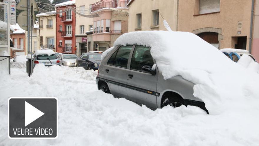 Un cotxe completament tapat per la neu amb la vorera emblanquinada al Pertús.