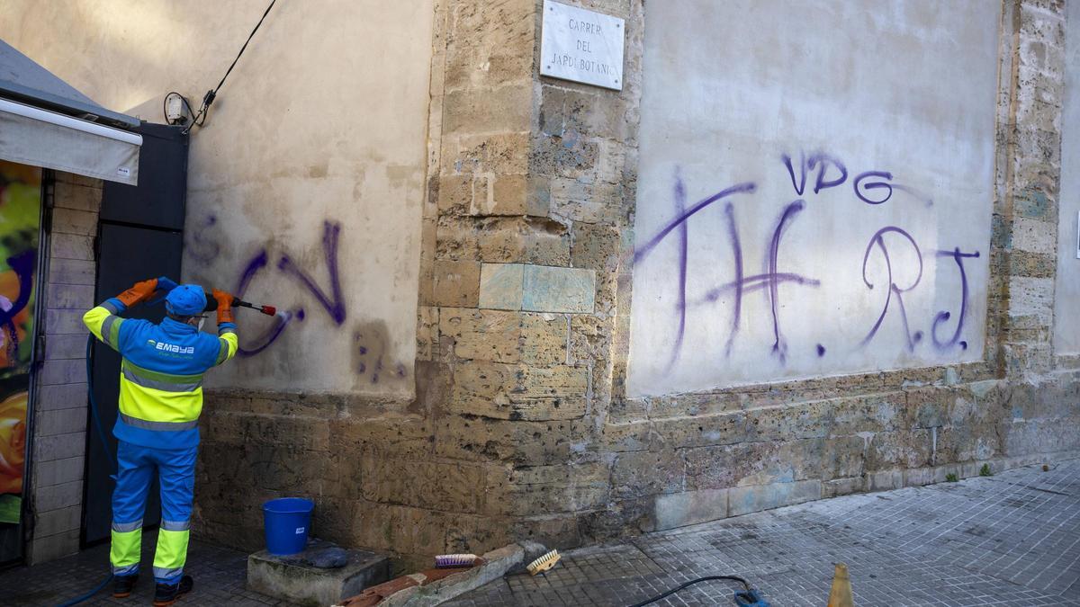 Operarios de Emaya limpian esta tarde las pintadas aparecidas en el muro del convento.