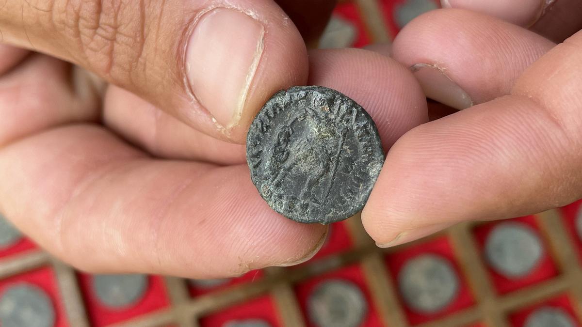 Una moneda de bronce con la figura del emperador Graciano, que coge con su mano la cabeza de un enemigo vencido.
