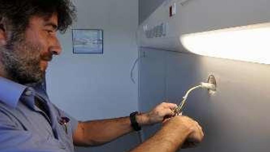 El electricista David Fernández revisa una de las tomas en otra habitación.