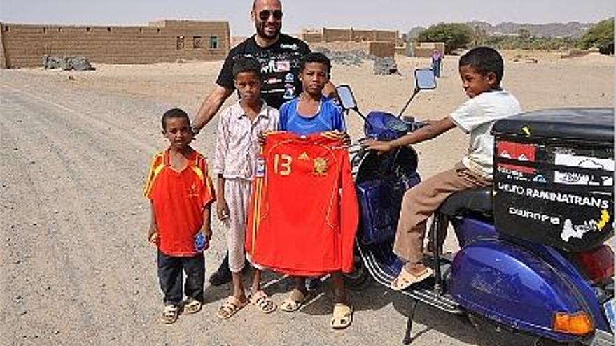 El profesor de educación física posa con la camiseta de la selección con unos niños sudaneses.