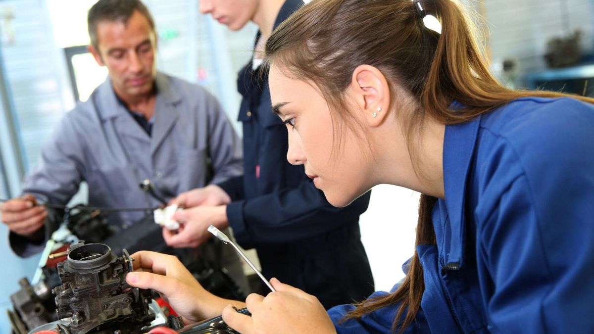 Una alumna de FP durante una clase. Una estudiante de formación profesional en una clase de mecánica. Mechanics training class with teacher and students