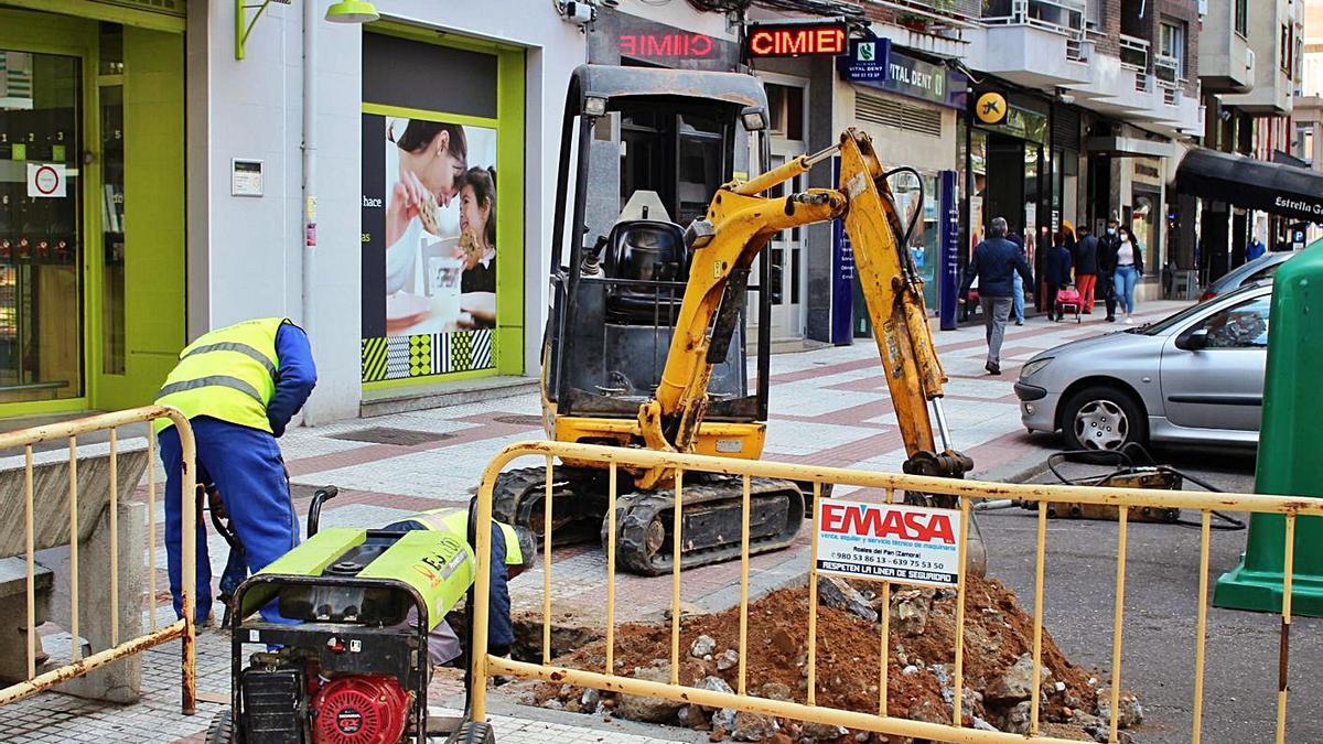 Trabajadores cavan una zanja en una acera de las Tres Cruces.