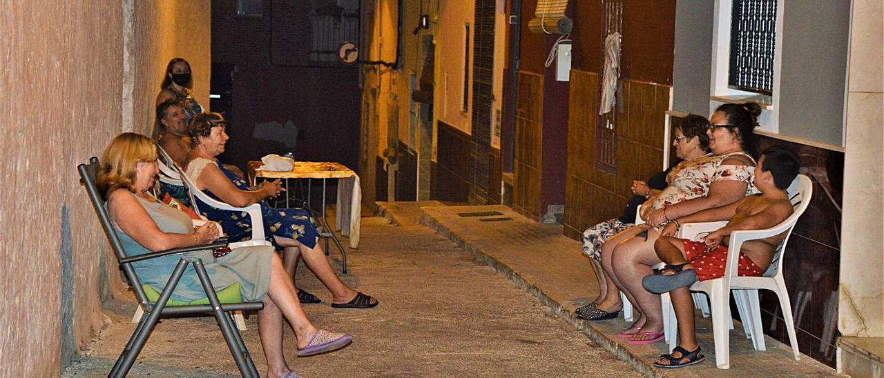 Una colla de veïns conversen al carrer del Crist de Carcaixent després de sopar.  | SERGI MOYANO