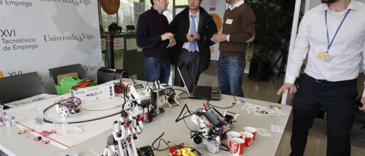 Roi Otero y Guillermo Sanjorge (1º y 2º por la derecha) muestran sus robots a los ingenieros. // J. Lores
