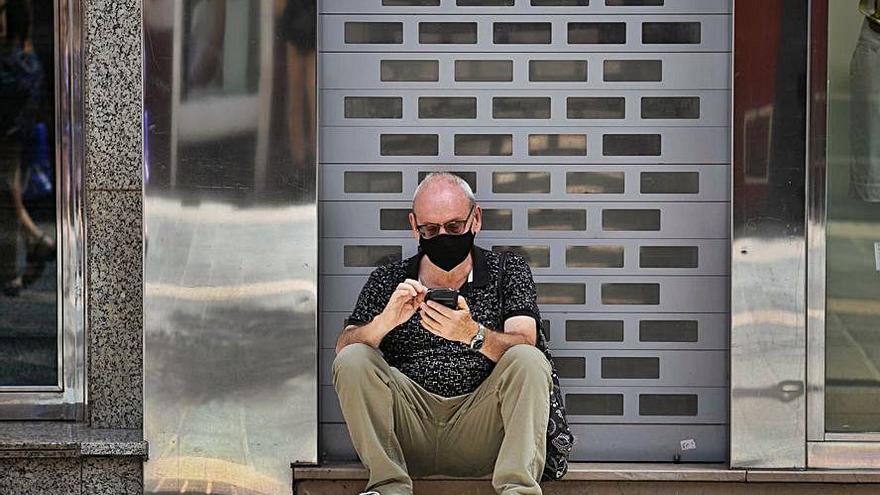 Un hombre consulta su dispositivo móvil.
