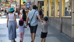 Archivo - Una familia pasea de la mano por una calle de Madrid.