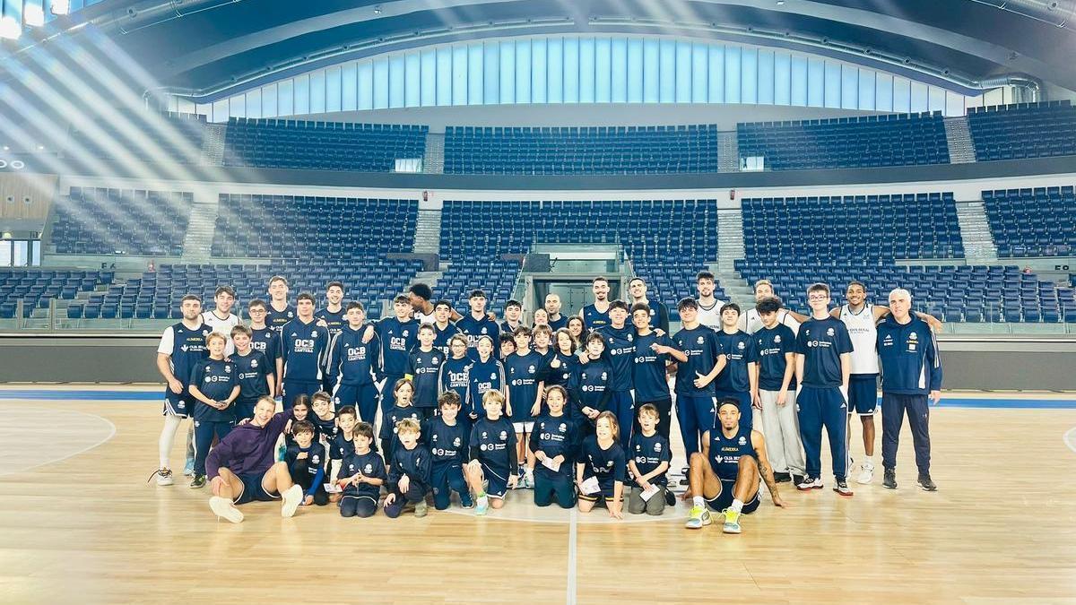 La plantilla del Alimerka Oviedo Baloncesto junto a los niños del campus de Navidad del club, en el Palacio de los Deportes.