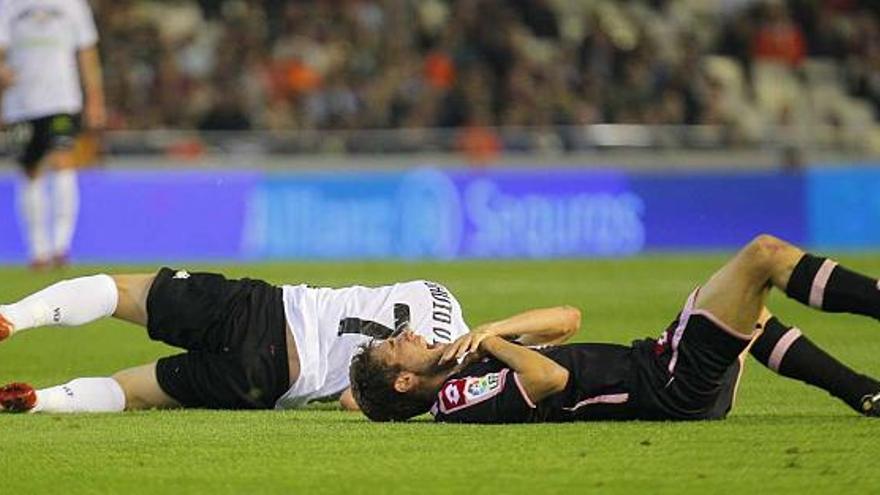 Villa y Piscu, en el suelo después del encontronazo que sufrieron durante el partido del sábado en Mestalla. / superdeporte