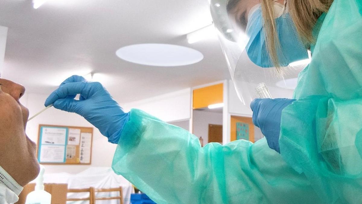 Una sanitaria recoge una muestra para realizar una prueba PCR