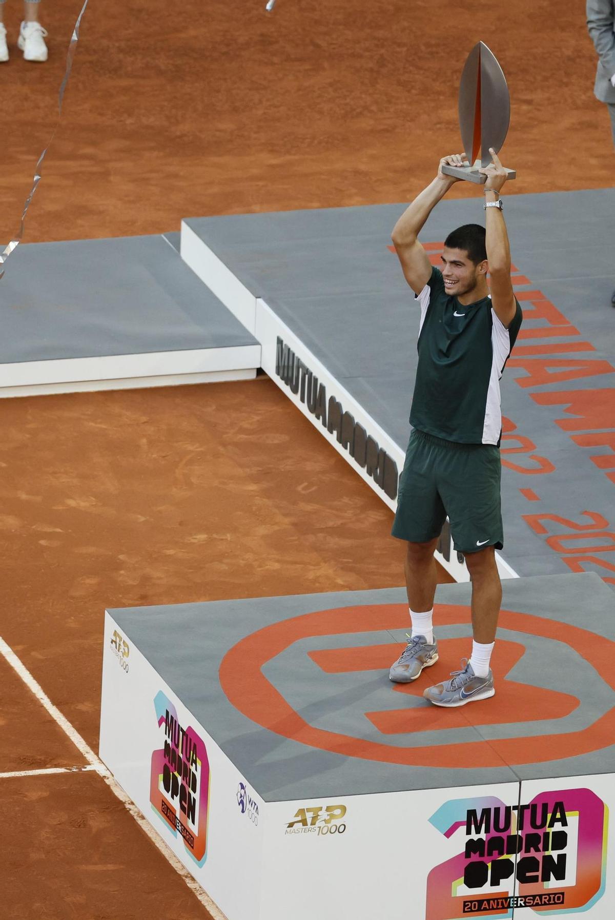 MADRID, 08/05/2022.- El tenista español Carlos Alcaraz alza el trofeo mientras celebra su victoria en la final de la Mutua Madrid Open tras derrotar al alemán Alexander Zverev en el encuentro disputado este domingo en las instalaciones de la Caja Mágica, en Madrid. EFE/Juanjo Martín.