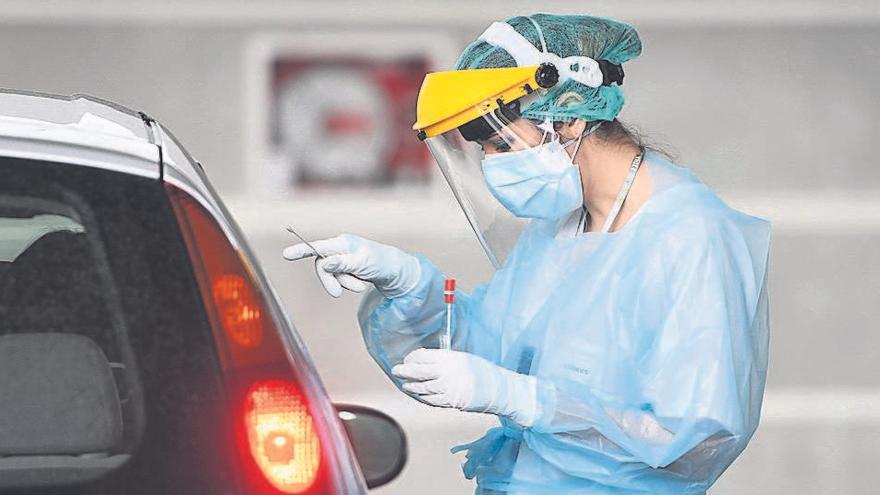 Una sanitaria se dispone a extraer una muestra para analizar a una persona en un coche.