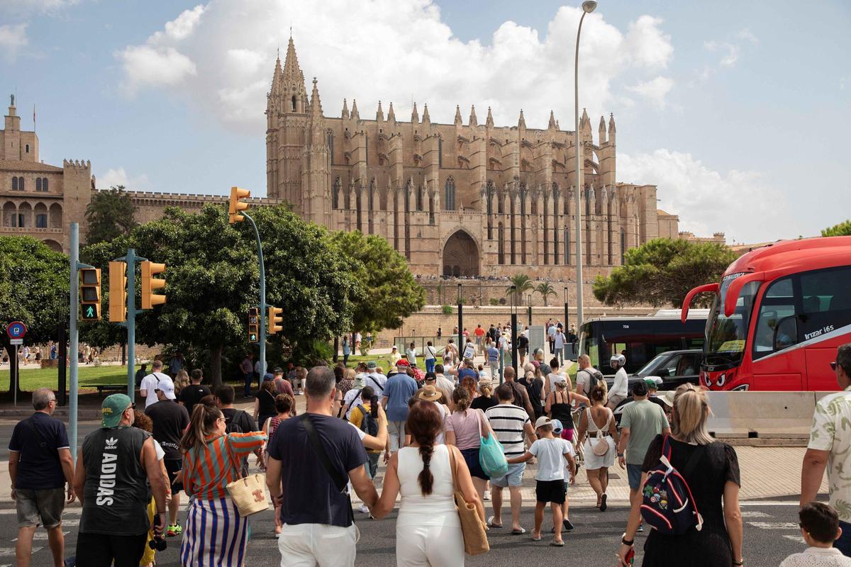 Menschen gehen an einem Sommertag an der Kathedrale von Palma.