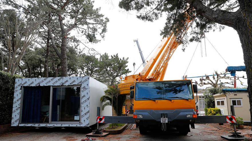 Uno de los nuevos bungalós, listo para colocar y la gran grúa que ayer levantó las casetas. // José Lores