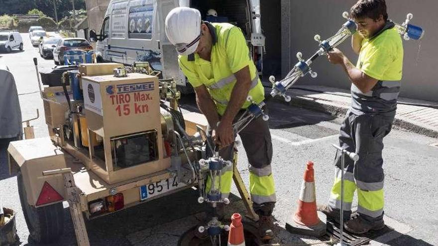 Los operarios introducen el robot en las tuberías, ayer. // Cristina Graña