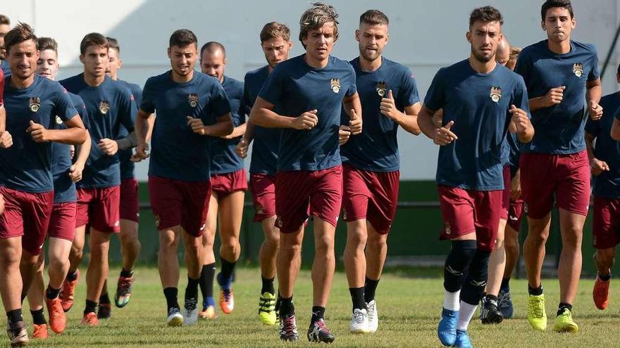 La plantilla al completo trotando durante un entrenamiento celebrado en el campo de A Seca, en Poio. // Rafa Vázquez