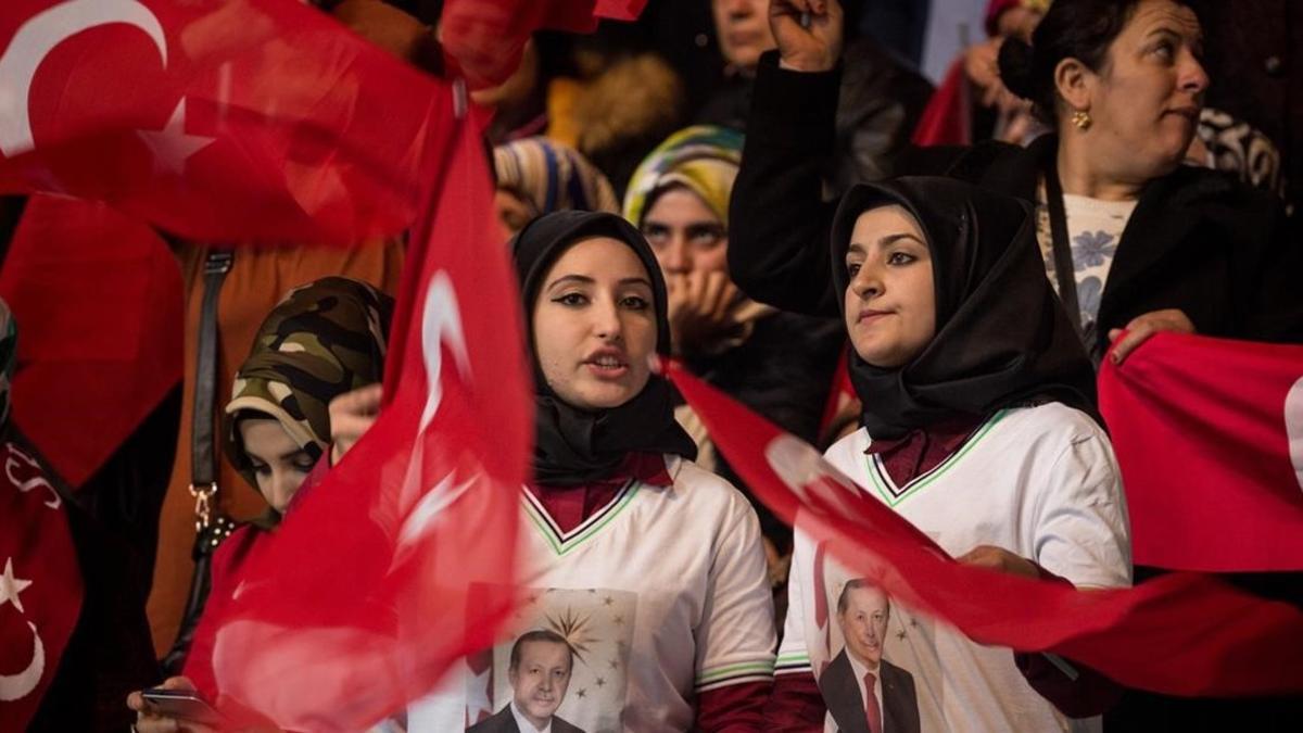 Dos mujeres con pañuelo y banderas turcas, en un mitin del partido gubernamental a favor del 'sí' en el próximo referéndum constitucional, en Ankara, el 25 de febrero.