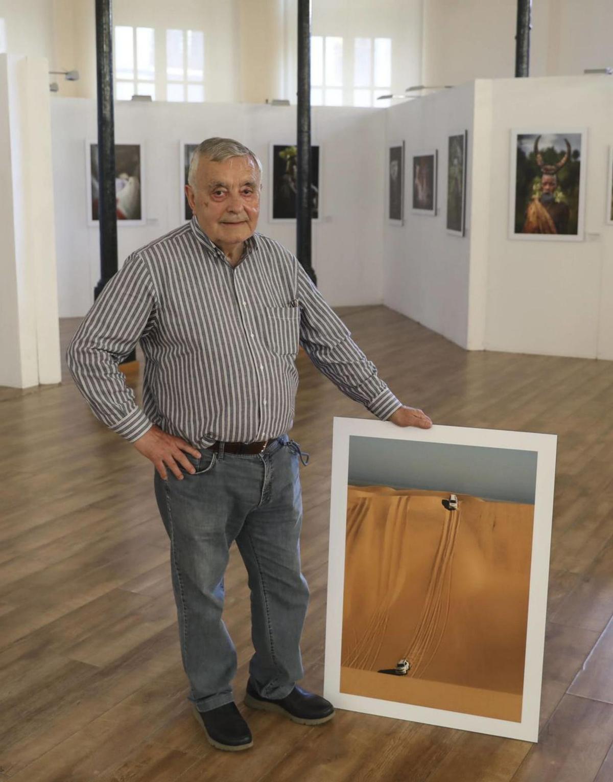 Emilio Cueto, entre sus fotografías, en la ovetense plaza de Trascorrales. LUISMA MURIAS