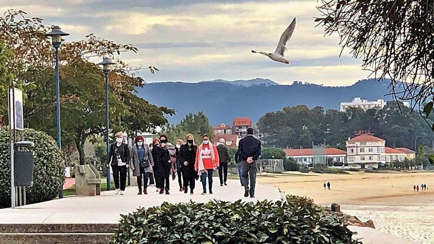 Gente paseando ayer por el frente marítimo de Cangas.