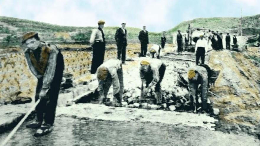 Os traballos de construción dunha estrada en 1926, con máis xente mirando que traballadores. 