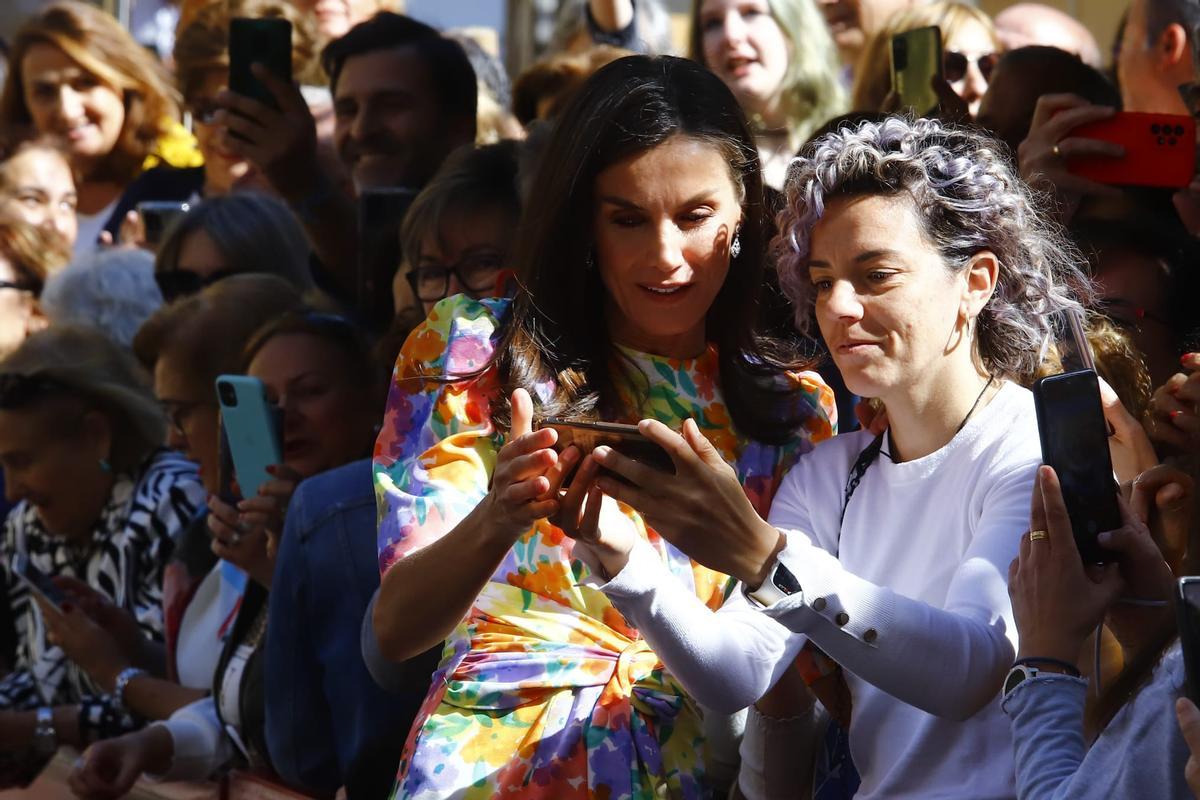 La Reina Letizia mira un selfie con una joven en Córdoba.